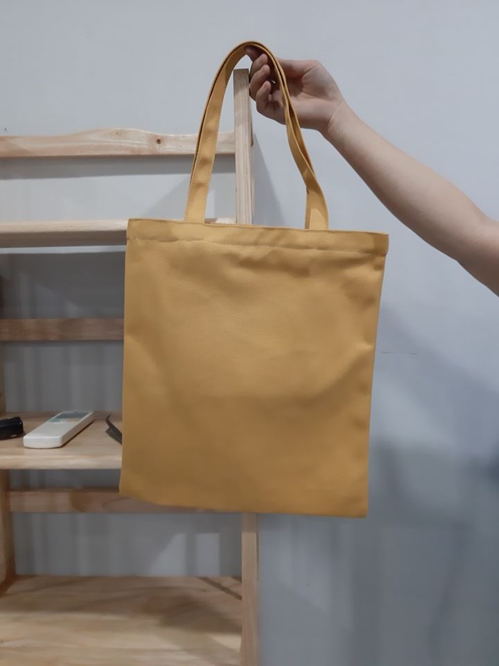 Chiếc túi canvas trơn màu vàng cho phép bạn dễ dàng kết hợp với nhiều kiểu trang phục khác nhau